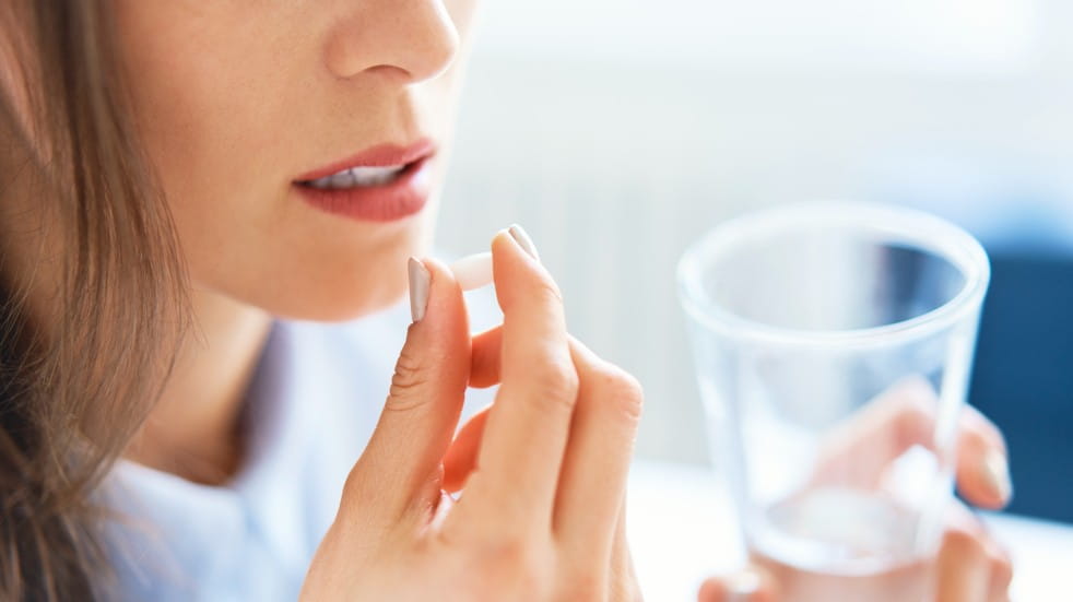 woman taking tablet